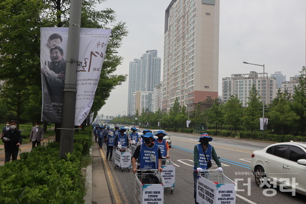 청라 롯데캐슬 앞 도로를 지나가는 인천공항 비정규 노동자들(사진=더청라)